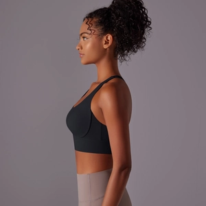 Vista laterale di un reggiseno sportivo nero incrociato e leggings da yoga a vita alta taupe