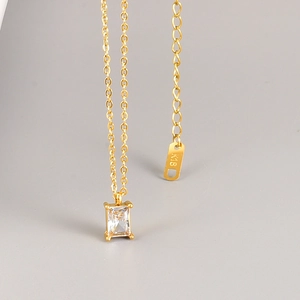 Detail of 18K gold plated necklace featuring square emerald zircon pendant and K18 tag