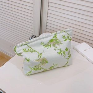 Trousse de maquillage brodée avec motif d'oiseau et fermeture éclair sur fond blanc