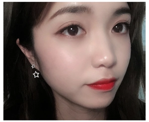 Close-up of sparkling silver star earrings with zircons on model ear