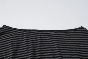 Detail of grey striped knit fabric with off-shoulder neckline and stitched seams