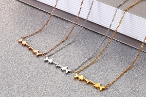 Detail view of heart-rate and fish necklaces in rose gold, silver, and gold steel