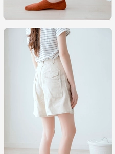 Detail of high-waist cargo shorts with flap pockets and striped t-shirt casual outfit