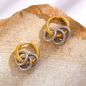 Minimalistische Gold- und Silber-Creolen mit ineinandergreifendem Design auf Stein