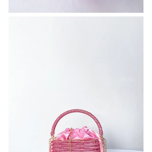 Close-up of pink beaded bucket bag with satin drawstring liner and golden chain strap