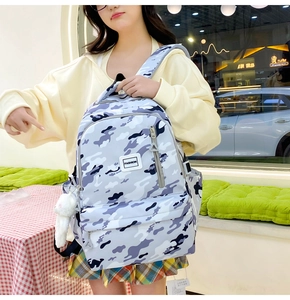 Close-up of camouflage school backpack with fashion logo and side storage pockets