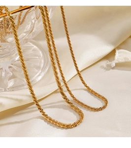 Detailed view of the gold sparkling star chain necklace on elegant beige silk background