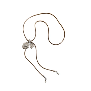 Vintage silver double heart pendant necklace with zircon on brown cord over white background