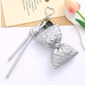 Quilted silver bow keychain with heart metal clasp and sleek lanyard on neutral background