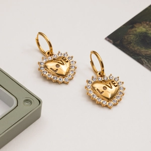 Gold heart drop earrings with LOVE engraving and crystal border on white background