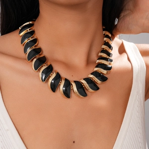 Détail du collier feuille irrégulier noir et or rétro avec une finition en émail