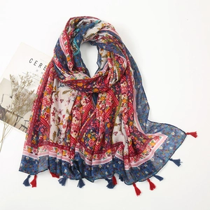 Floral cotton linen scarf with ethnic prints and bohemian tassels in a flat lay view
