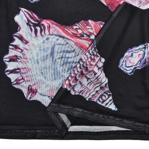 Close-up of mesh fabric with shell print and black stitched hem on a summer dress