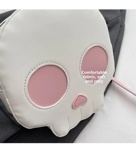 Detail of funny skull crossbody bag showing soft white PU leather and pink contrast stitching