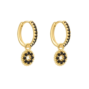 Détail de boucles d'oreilles huggie dorées avec oxydes de zirconium noirs pavés