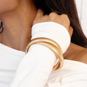 Macro detail of golden twisted bracelet showing precision spiral texture and metal finish