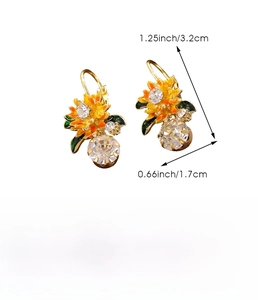 Détail de boucles d'oreilles pendantes avec émail tournesol et cristal de forme poire