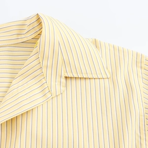 Macro shot of yellow and white vertical striped shirt collar with detailed stitching