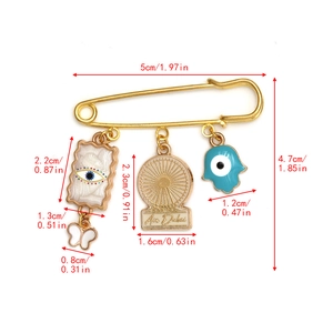 Detailed size chart of a golden evil eye safety pin brooch with Fatima Hand charms
