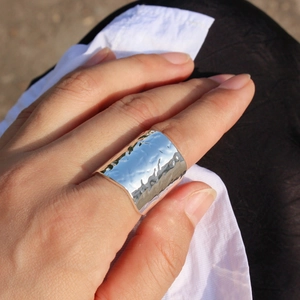 Unisex lava textured wide open ring in silver finish worn by a model in natural light