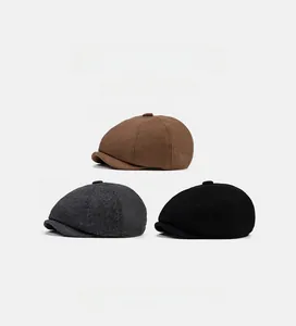 Detailed flat lay of three wool blend newsboy caps in brown, dark grey and black colors