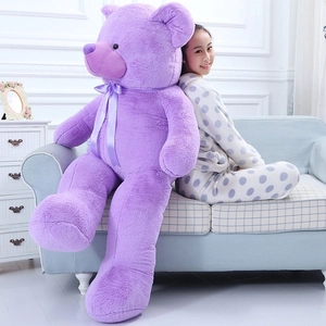 Large purple teddy bear plush shown next to a person to demonstrate its giant size