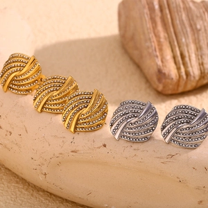 Close-up of vintage twisted hoop earrings with white zircon pavé in gold and silver