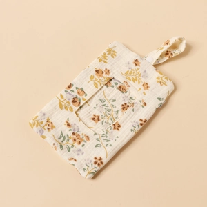 Detail of baby wipes holder with floral pattern, cotton gauze fabric, and snap-on strap