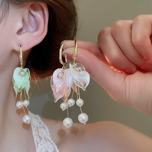 Detailed view of floral tassel earrings with acrylic petals and hanging pearls