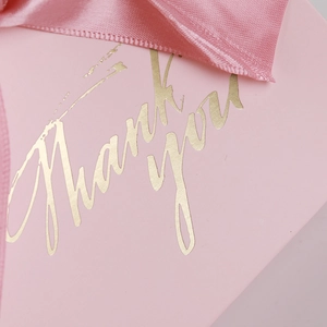 Detailed close-up of pink gift box with gold Thank You foil and matching ribbon bow