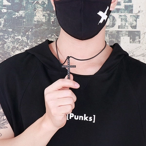 Détail du collier avec pendentif croix en acier inoxydable noir sur un mannequin