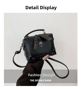 Detail of black punk style crossbody bag featuring silver skull emblem and metal rivets