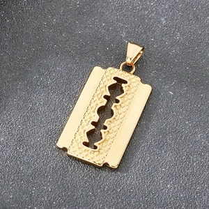 Close-up of golden vintage razor blade pendant with intricate hollowed textures