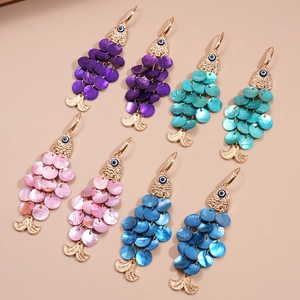 Handmade fish shaped shell earrings with golden evil eye accents in four vibrant colors