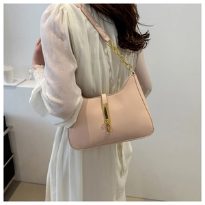 Detail of pink leather underarm bag with gold metal buckle and chain shoulder strap