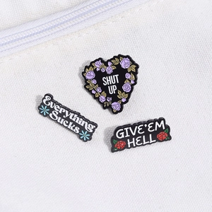 Vue détaillée de trois broches en émail et métal avec divers motifs floraux