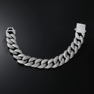 Detailed view of silver Cuban link bracelet with micro-pave cubic zirconia on black background