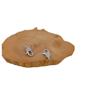 Silver plated lobster clasp with micro-pave cubic zirconia on a wooden base