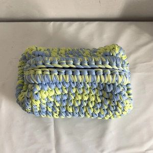 Detailed close-up of handmade woven tissue box cover made with thick blue and yellow yarn