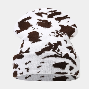 Close-up of thick knitted beanie showing brown cow print pattern and soft wool texture