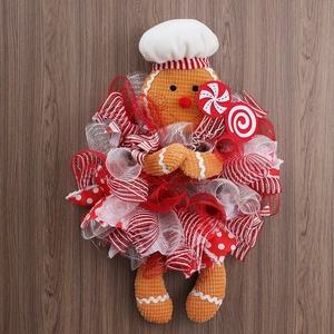 Detail of Christmas gingerbread man chef wreath decoration on a rustic wooden background