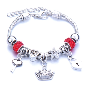 Silver charm bracelet with red crystals and crown heart pendants on snake chain