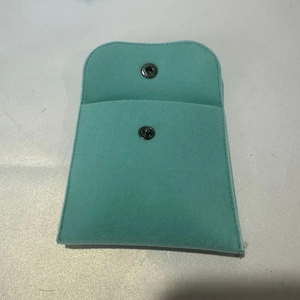 Macro detail of Tiffany blue velvet jewelry pouch with silver metal snap button closure