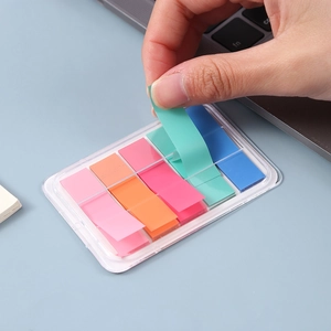 Note adesive in PET colorate in scatola con mano che solleva una linguetta indice verde