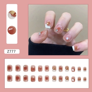Short blush French press-on nails with 3D diamond accents and gold foil flakes design