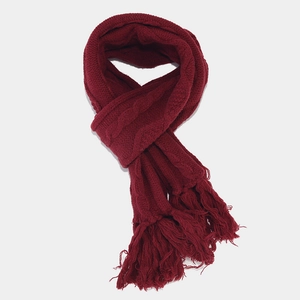Detail view of a wine red cable knit scarf with thick fringe tassels and soft texture