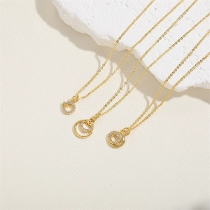 Three gold geometric pendant necklaces with zircons displayed on white plaster stones