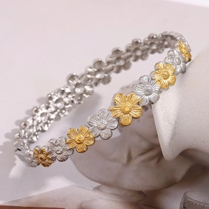 Nahaufnahme des zweifarbigen 18K vergoldeten Gänseblümchen-Armbands aus Edelstahl