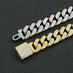 Détail des chaînes à maillons cubains or et argent avec incrustation de strass brillants