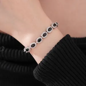 Elegant silver bracelet featuring oval black stones with halo zircon on a female wrist